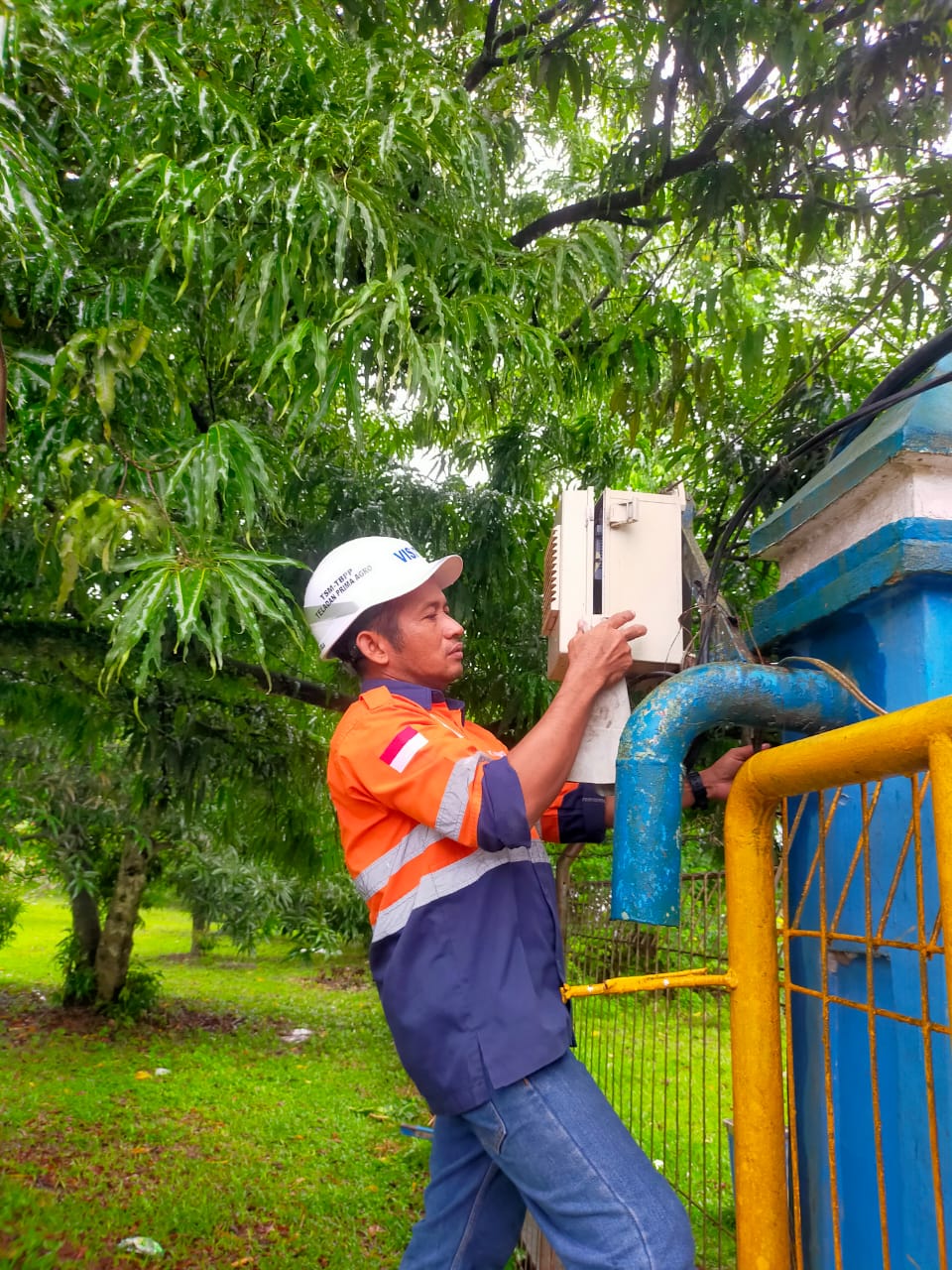 Petugas lapangan memeriksa perangkat di area perkebunan